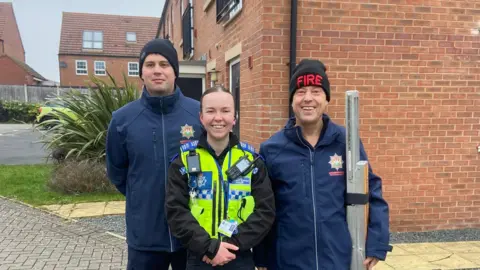 Leicestershire Police A PCSO and two fire service workers stood on a housing estate