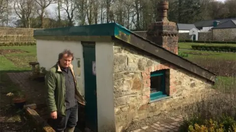 Horticulturalist Simon Richards outside the pineapple house