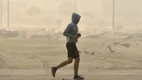 Getty Images A person jogs near a ground despite the AQI being very poor to hazardous, on November 13, 2021 in Noida, India.