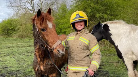 Storm (left) standing next to a crew member from County Durham and Darlington Fire and rescue Service 