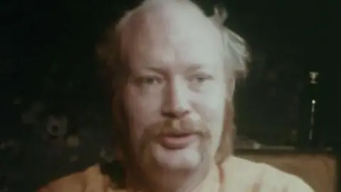 Sam Green. He is balding pinch a ginger moustache and sideburns