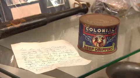The can of beef dripping with the handwritten letter next to it.