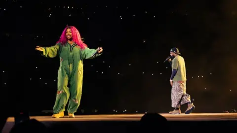 Cassidy Meyers SZA appears in a jumpsuit alongside Kendrick Lamar in a green top and trousers