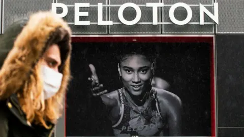 Getty Images Woman walks past Peloton store