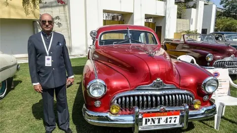 AFP Maharaja Bhagirath Singh of Idar poses next to his USA's 1948 Buick Eight Super car during an exhibition of vintage cars and bikes organised by Gujarat Vintage and Classic Car Club (GVCCC) in Ahmedabad on February 8, 2020.