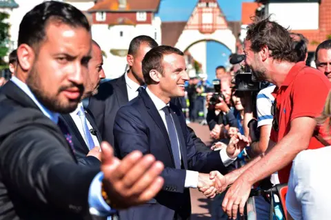 AFP French President Emmanuel Macron (C) shakes hands with people after he voting in Le Touquet, northern France