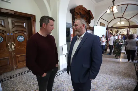 Liam McBurney Sinn Fein's John Finucane (left) and UUP leader Doug Beattie speaking at the Northern Ireland council elections at Belfast City Hall.