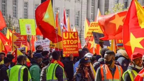 Getty Images 2021/04/25: Protesters gather while holding Tigray flags during the demonstration. Thousands of people marched through Central London in protest of what the demonstrators call Ethiopia's and Eritrea's "genocidal war" on the region of Tigray.