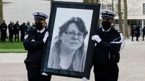 Getty Images rench police officers hold the portrait of murdered Stephanie Monferme, a mother and local police employee, during a remembrance gathering, in Rambouillet, a suburb southwest of Paris on April 30, 2021