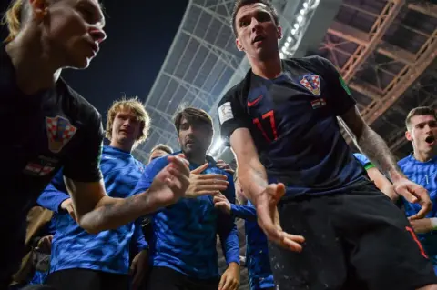 Yuri Cortez/AFP Croatia's forward Mario Mandzukic (C) offers to help AFP photographer Yuri Cortez after he fell on him with teammates while celebrating their second goal