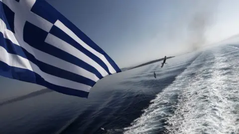 Getty Images The Greek flag flying at the stern of a ship