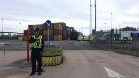 BBC Police officer standing outside freight terminal