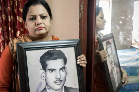 Amirul Rajiv Suraya Parveen with a photo of her father Mejbah Uddin Ahmed