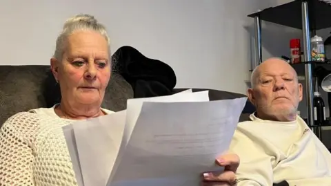 A view of Amanda and Stuart Nunnley looking at their eviction notices.
