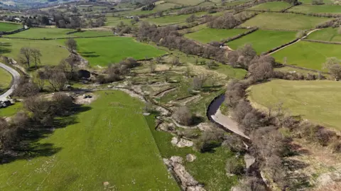An ariel photo of a river restoration wetland project in the Upper Teme catchment. It shows a river surrounded by wetland areas and fields.