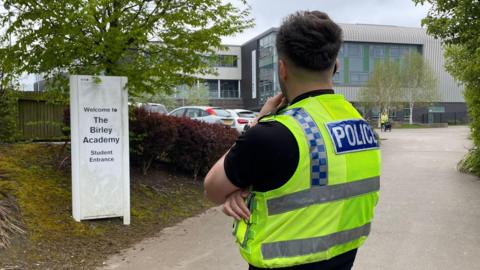 Police officer standing outside Birley Academy in Sheffield 