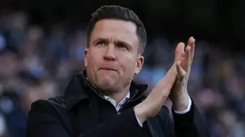 Gary Caldwell applauds Exeter fans at the Etihad Stadium in an FA Cup tie