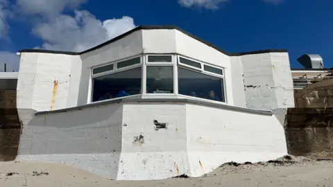 A white building with a large window.
