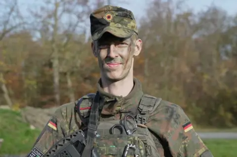 A young man wearing military fatigues