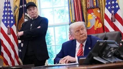 Tesla CEO Elon Musk and U.S. President Donald Trump listen to a question from reporters in the Oval Office of the White House on May 30, 2025 in Washington, DC
