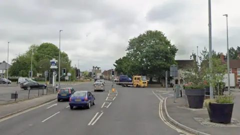Google A screenshot from Google Maps showing Whitworth Road, close to the junction with Cricklade Road. There are traffic lights and a few cars on the road.