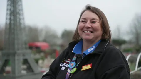 Paula Laughton wearing her Lego uniform and smiling at the camera.