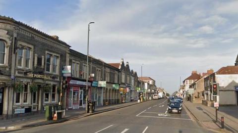 Staple Hill High Street - a road with traffic lights and a row of shops with the Portcullis Pub