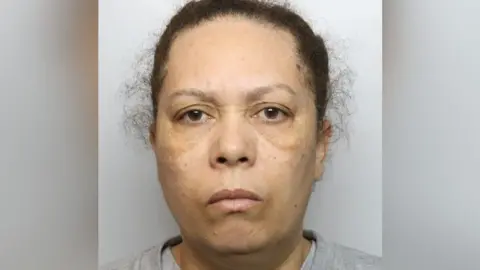 Staffordshire Police Veronique John in a picture taken by police. She is wearing a grey top and is looking straight at the camera. Her hair is tied back.