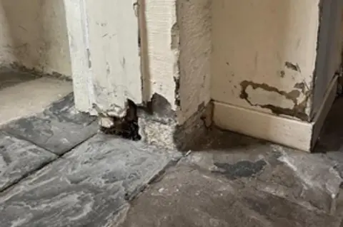 HMIPS The entrance to a cell, with chipped and broken stonework near the ground