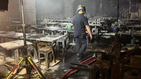 Fire and Rescue Thailand/ Getty Images Emergency workers operate inside the Rong Beer Na Ladprao pub following a midnight fire in the Chatuchak district of Bangkok, 