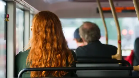 Stock image of people sat on a bus