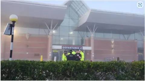 Jersey airport on the day of the incident in March. Police are stood outside the airport. 