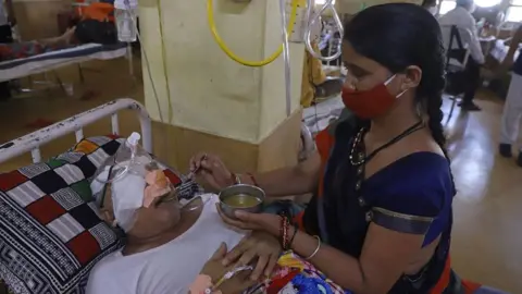 AFP An attendant is seen next to a patient who recovered from the Covid-19 coronavirus and is now infected with black fungus, a deadly fungal infection at the Netaji Subhash Chandra Bose Medical College in Jabalpur on 21 May 2021