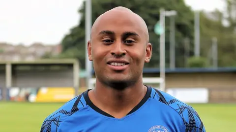 Richard Chappell Photography Tyreke Johnsn looks in the camera wearing his blue football kit.