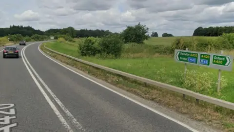 Part of the A420 near the Pusey turning. There are signs for Oxford and Swindon and Bristol pointing in opposite directions. Cars are seen driving away towards Swindon. It is overcast.