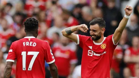 Reuters Manchester United's Bruno Fernandes celebrates with Fred after scoring their fourth goal to complete his hat-trick