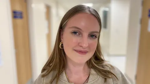 BBC photo of Eliza standing in a hospital hallway