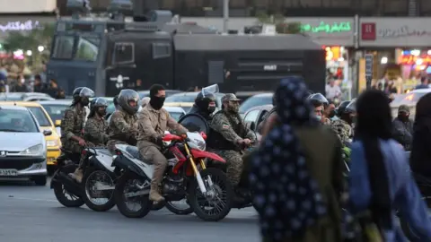 Wana via Reuters Iranian riot police ride motorbikes through Tehran, Iran (3 October 2022)