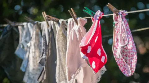 Getty Images Colourful underwear hanging on a washing line, clipped with wooden pegs. 