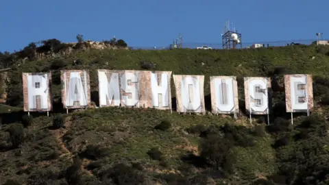 Getty Images A wide shot of the Hollywood Hills shows the Hollywood sign's letters covered in order to spell out RAMSHOUSE - a reference to American Football team LA Rams.