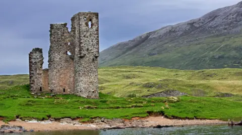 Getty Images The castle resembles a tall crumbling tower and stands within a landscape of high hills.