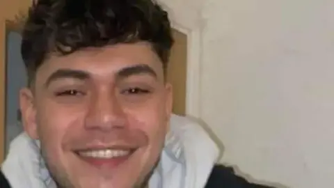 Derbyshire Police An image of Owen Fairclough smiling, wearing a white hooded garment