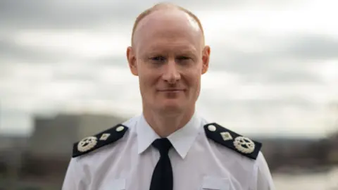 Alexis Boon wearing his uniform looking straight at the camera with a slight smile.