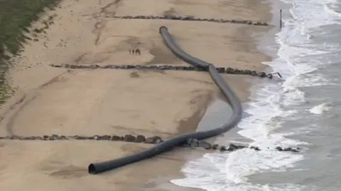 Aerial view of segments on the pipeline on a sandy beach