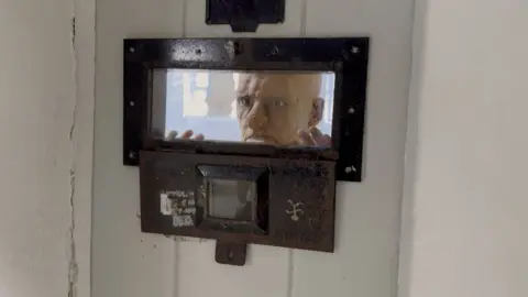 Visitors are confronted with scenes such as models of prisoners staring out of cells