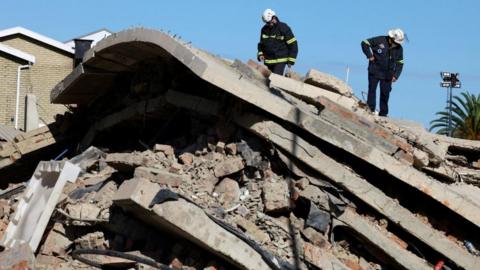 Rescue workers on top the rubble of the collapsed building
