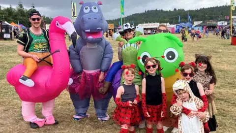 The families are dressed in blow-up animal costumes and polka dot dresses and animal print onsies.