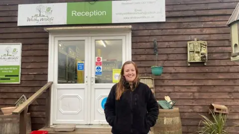 BBC A woman stands in front of the reception entrance at Whitby Wildlife Sanctuary.
