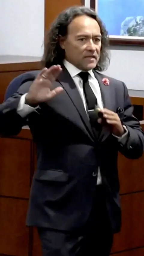A defence attorney in a suit delivering an opening statement.
