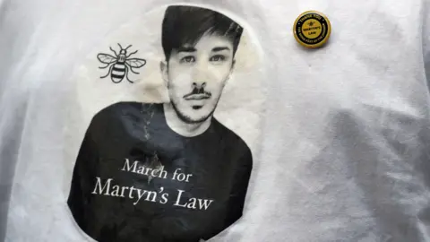 PA Media The image of Martyn Hett, a victim of the Manchester Arena bombing, on a T-shirt.